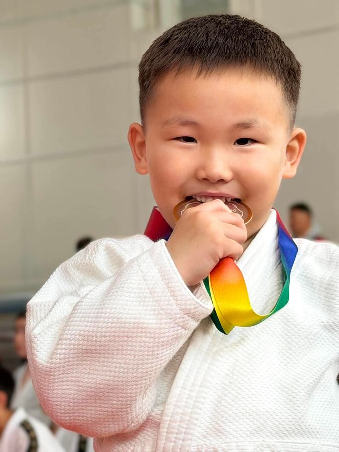 Young judo student with a medal