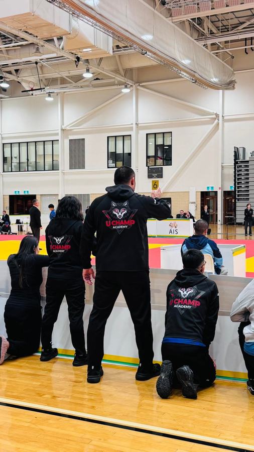 U Champ coaches courtside at a competition